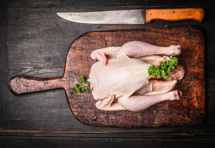 Raw whole chicken with knife