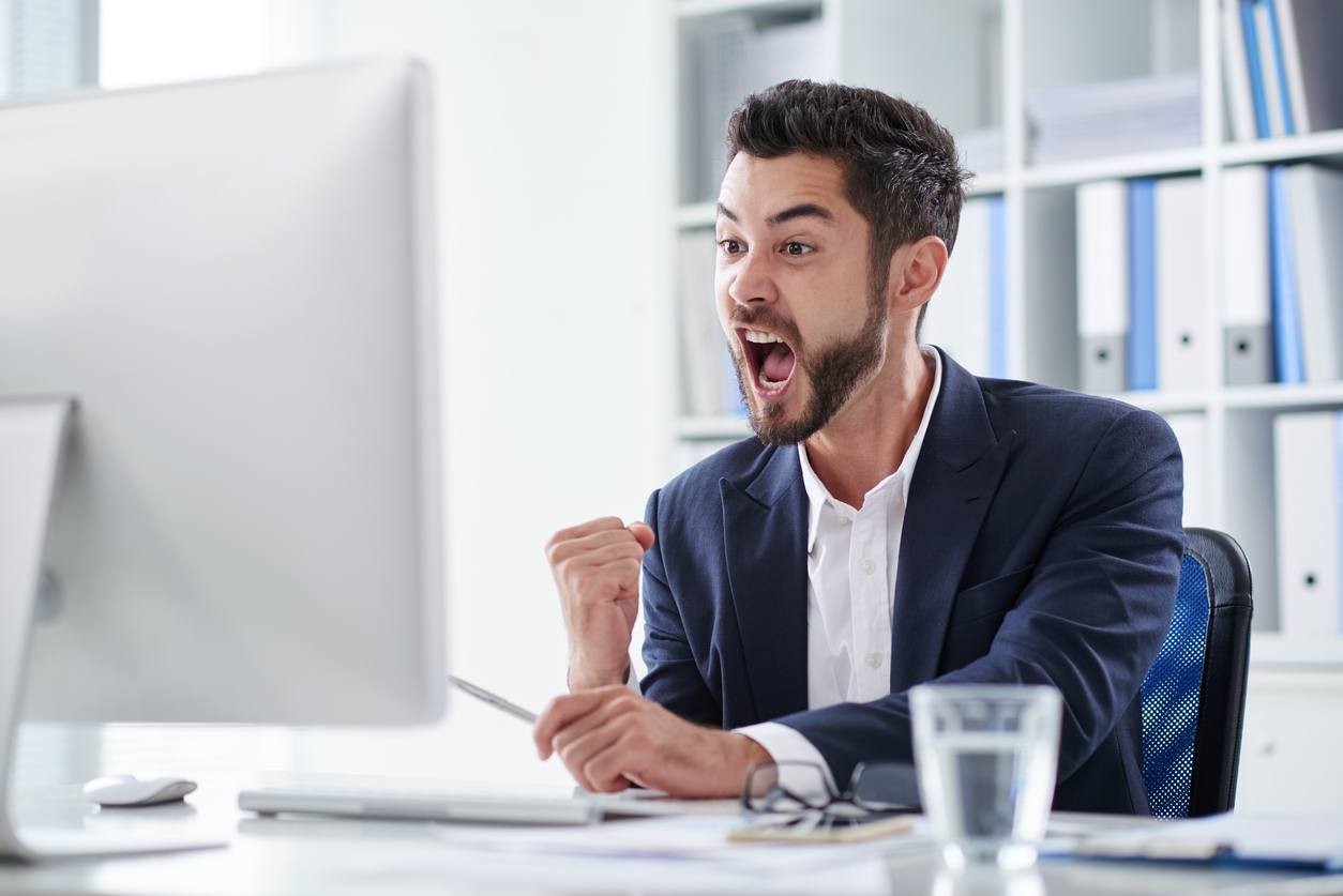 young entrepreneur screaming of joy when looking at computer screen