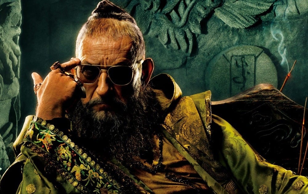 The Mandarin, wearing sunglasses, and pointing to his forward with his right hand