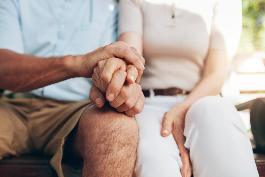 Close up shot of senior couple holding hand