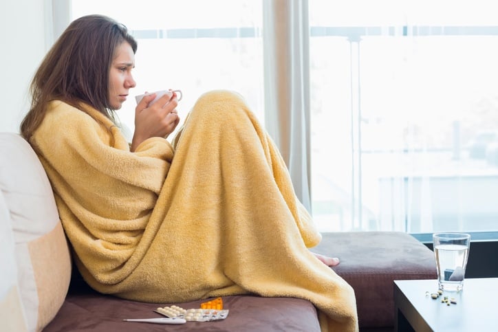 Side view of sick woman having coffee