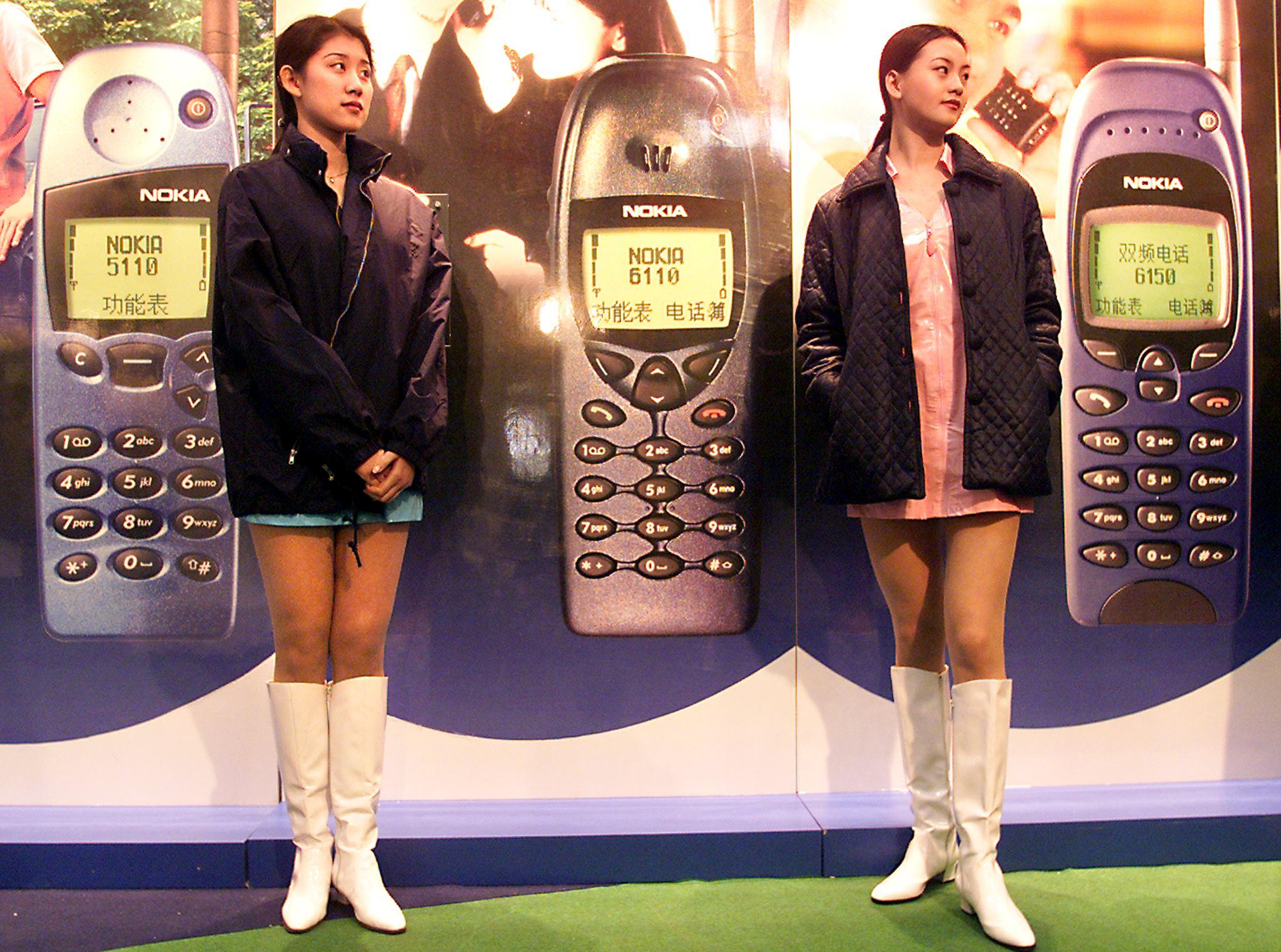 Two young Chinese women working for Nokia stand ready to help customers