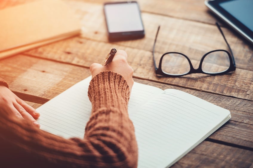 image of woman writing, working