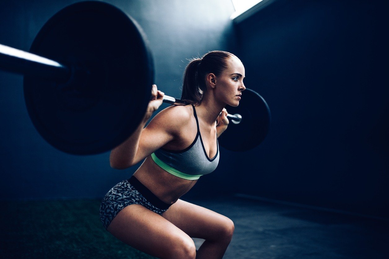 Athlete demonstrates a squat with a barbell