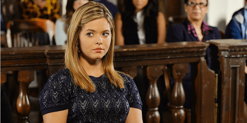 Alison looks serious as she's sitting in a court room in Pretty Little Lairs.
