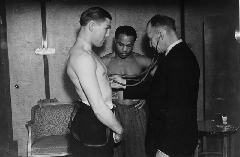 A doctor listens to an athlete's heart, gauging for possible heart attack signs