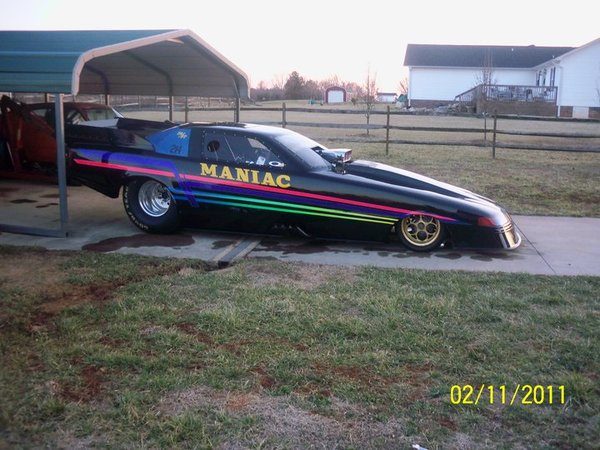 The Maniac parked near a carport on a driveway