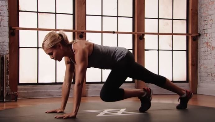 Fitness trainer demonstrates how to perform an ab exercise