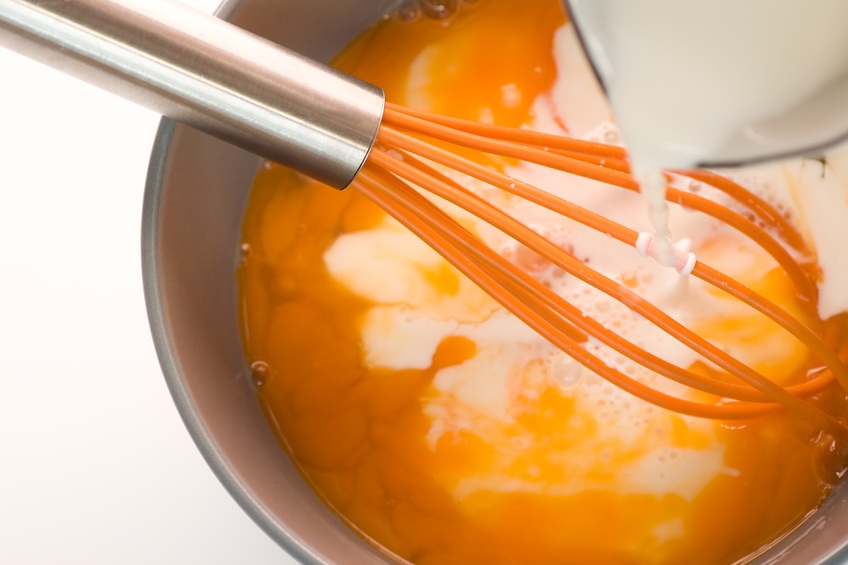 Pouring milk in omelet