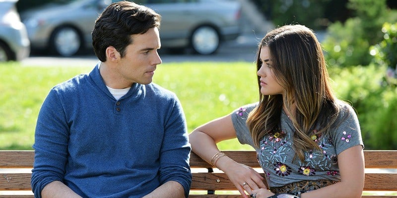 Aria and Fitz are sitting on a park bench talking on Pretty Little Liars.