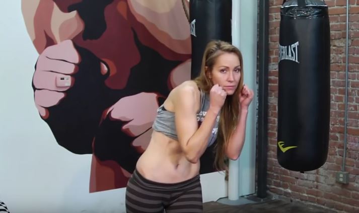 An Olympic-certified boxing trainer demonstrates an ab exercise