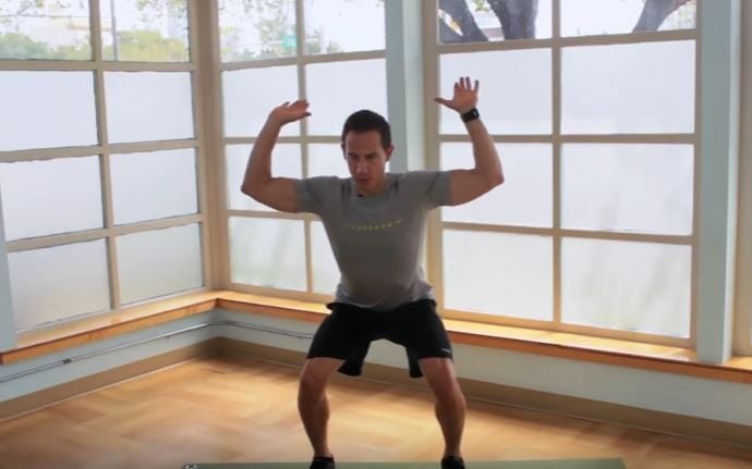 Fitness instructor Jeremy Shore demonstrates a squat and reach