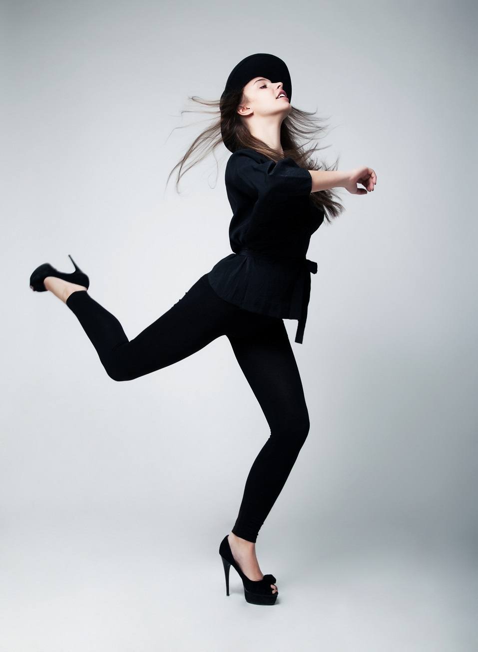 Fashion model girl in black running in studio
