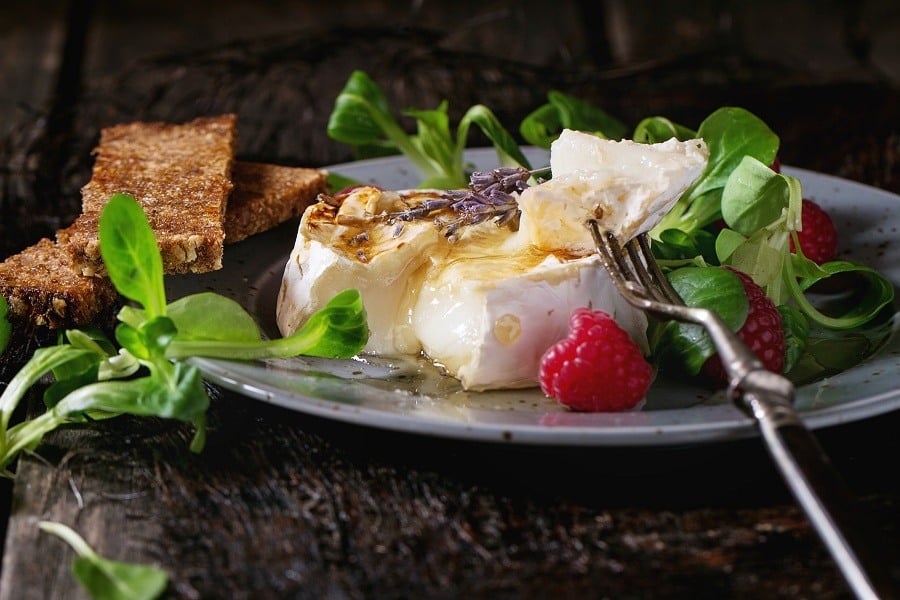 Melting sliced grilled goat cheese on blue plate