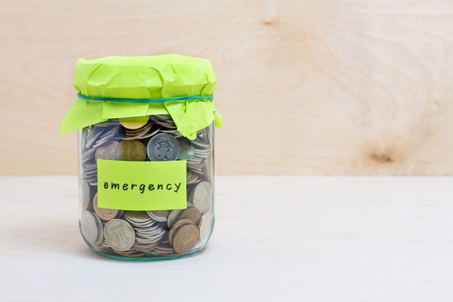 Coins in glass money jar with emergency label