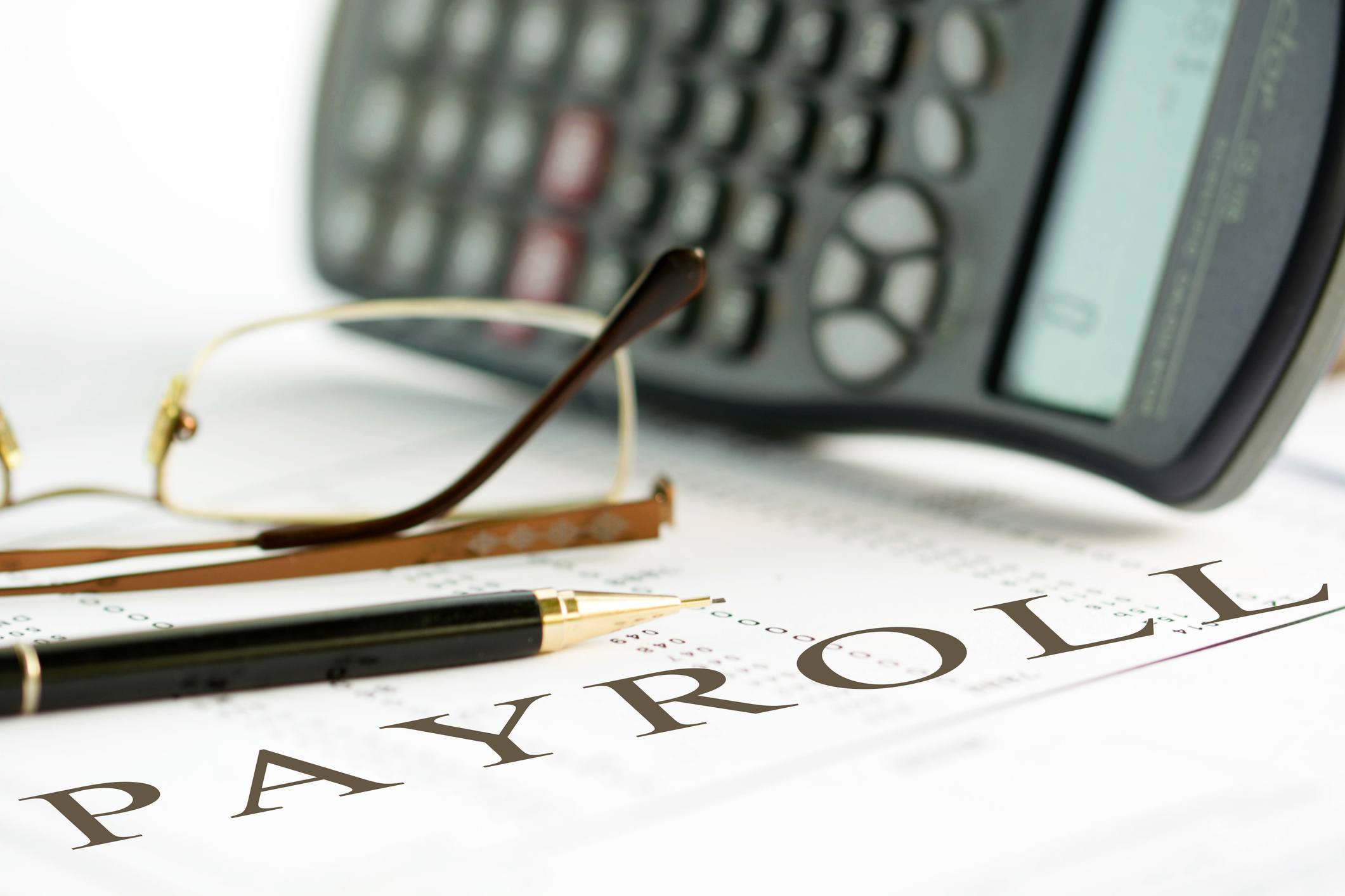 payroll sheet wtih pen and glasses