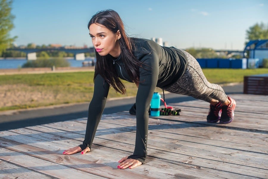 Fit woman doing full plank core exercise