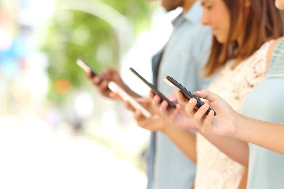 Four friend hands texting on their smartphones