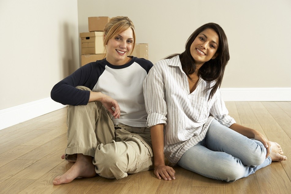 friends sitting on the floor of empty new home