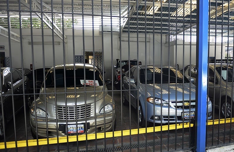 A man looks at used cars at a car dealer in Caracas on October 30, 2012. Venezuela, the country with the largest oil reserves and the world's cheapest gasoline, has the peculiarity that the supply of new cars has dropped and prices soared, especially that of the used ones.
