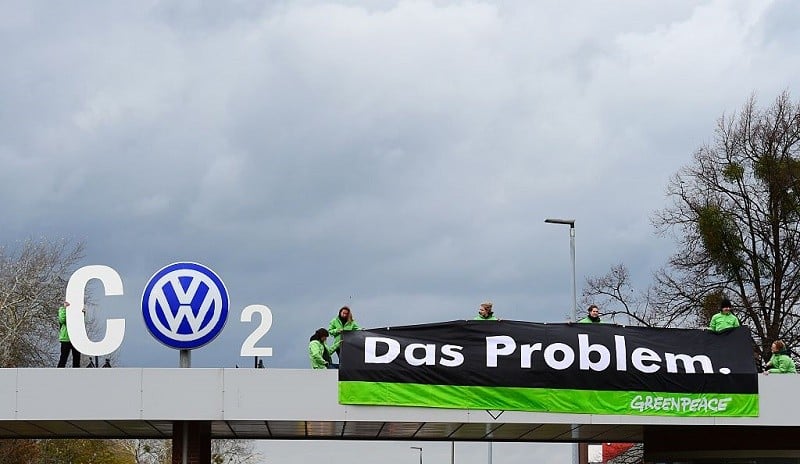 Greenpeace activists demonstrate at the entrance to the Volkswagen (VW) plant in Wolfsburg, central Germany, on November 9, 2015. Germany's consumers association wants auto giant Volkswagen to offer vouchers as a form of compensation to German customers affected by the massive pollution cheating scandal. VW is engulfed in a massive pollution scandal that has so far centred on so-called defeat devices, sophisticated software fitted into diesel engines to skew the results of tests for nitrogen oxide emissions. But the embattled auto giant said an internal probe had uncovered "inconsistencies" on carbon emissions as well, affecting not only diesel engines but petrol engines, too. AFP PHOTO / JOHN MACDOUGALL