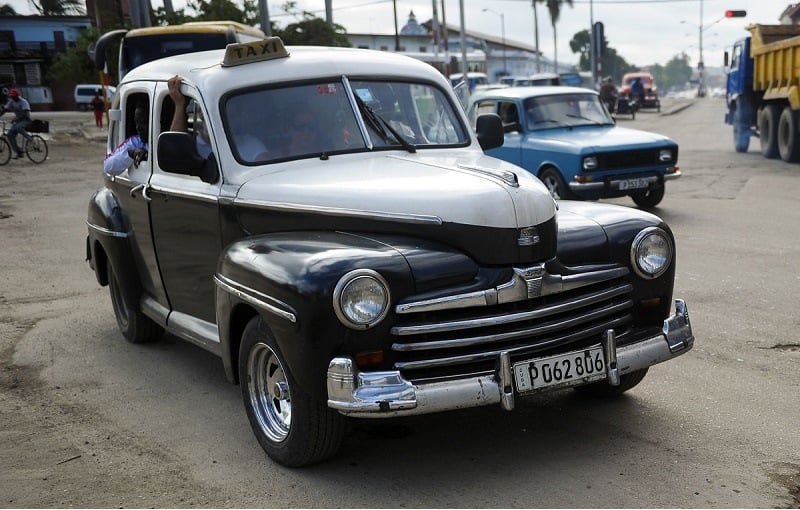 TO GO WITH AFP STORY by Rigoberto Diaz People drive cars along the streets of Havana, on January 11, 2016. A third of the cars riding in Cuba do so with mechanical failures and on destroyed roads.