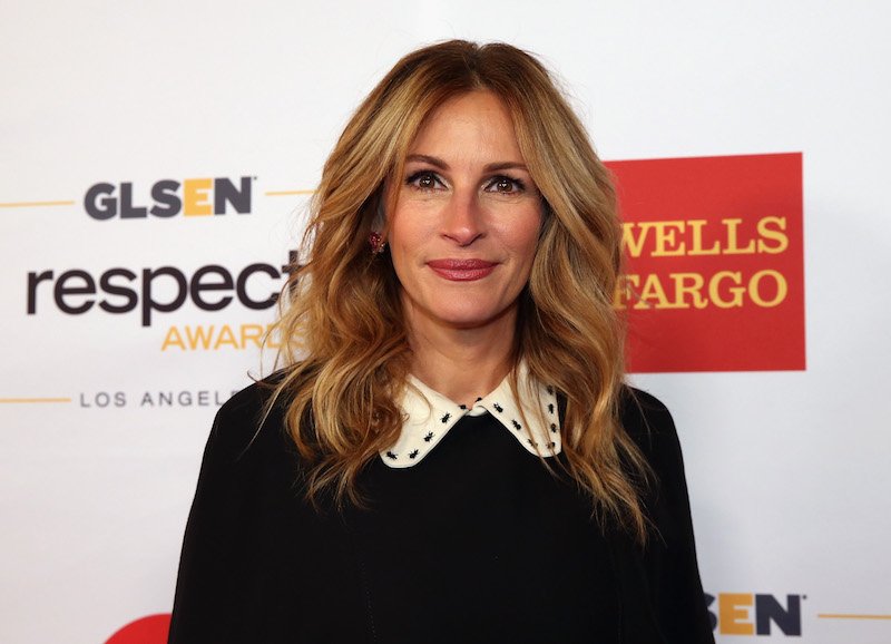 Julia Roberts smiling, in front of a Wells Fargo background on the red carpet