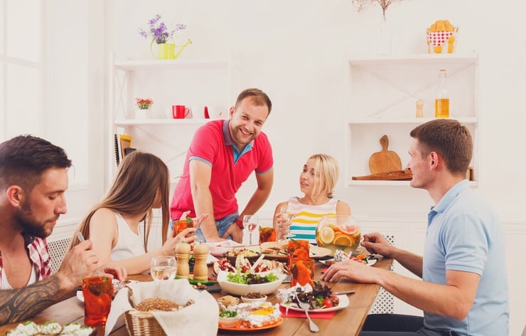 happy young people laugh and chat at dinner table