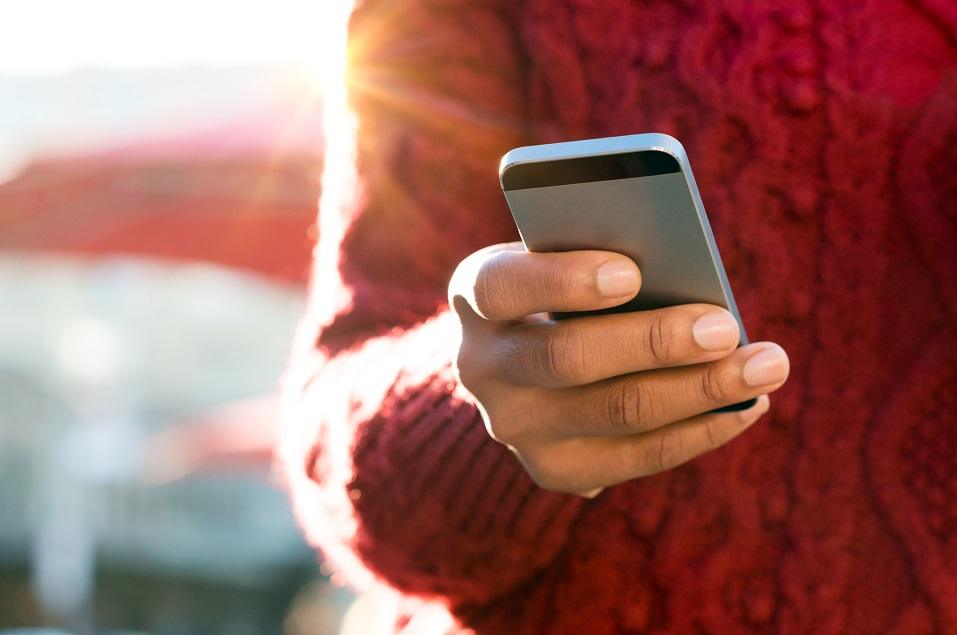 young woman's hand typing a text message on her smartphone