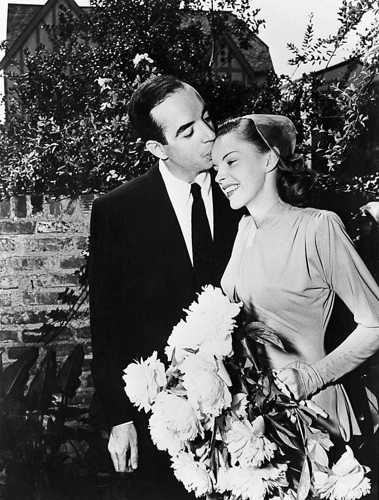 Film director Vincente Minnelli (1903 - 1986) kisses singer and actress Judy Garland