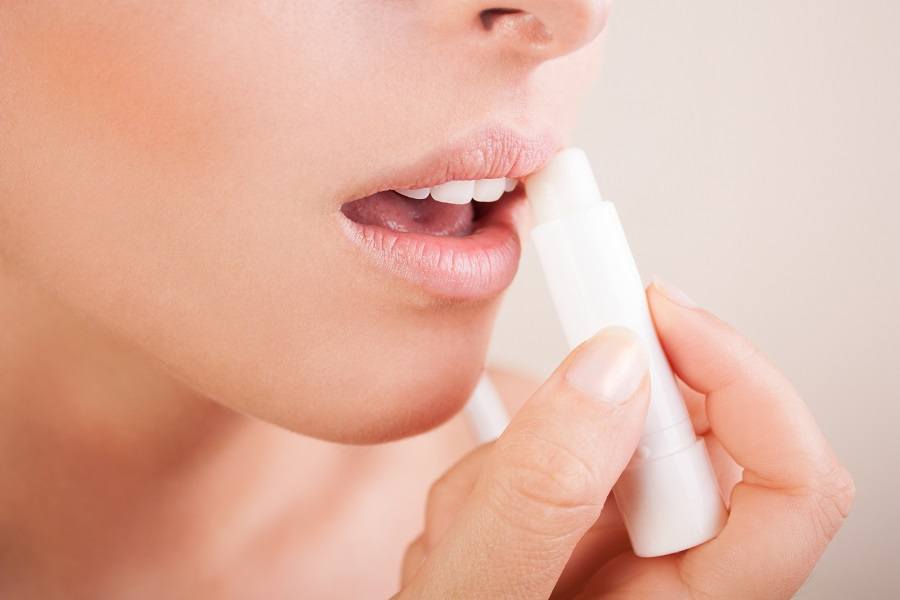 woman applying lip balm