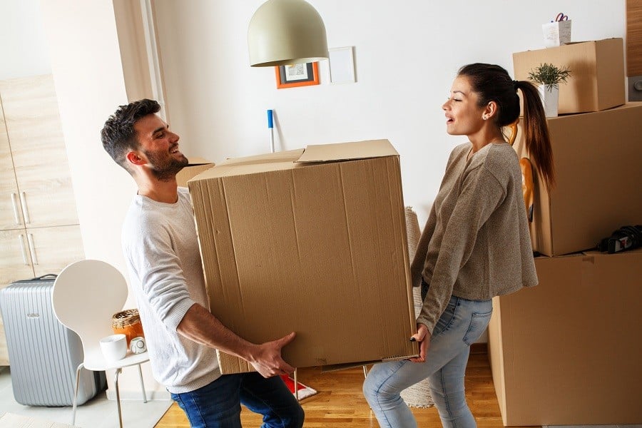 couple carrying big cardboard box