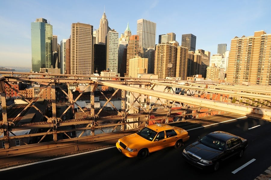 Taxi and a limousine driving along the Brooklyn Bridge