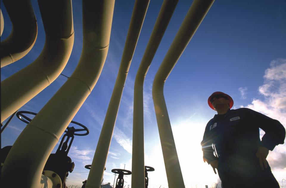 A pipeline worker inspects piping