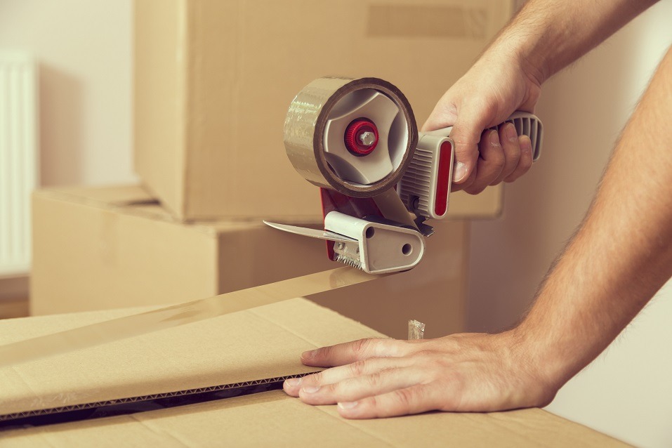 guy's hands holding packing machine