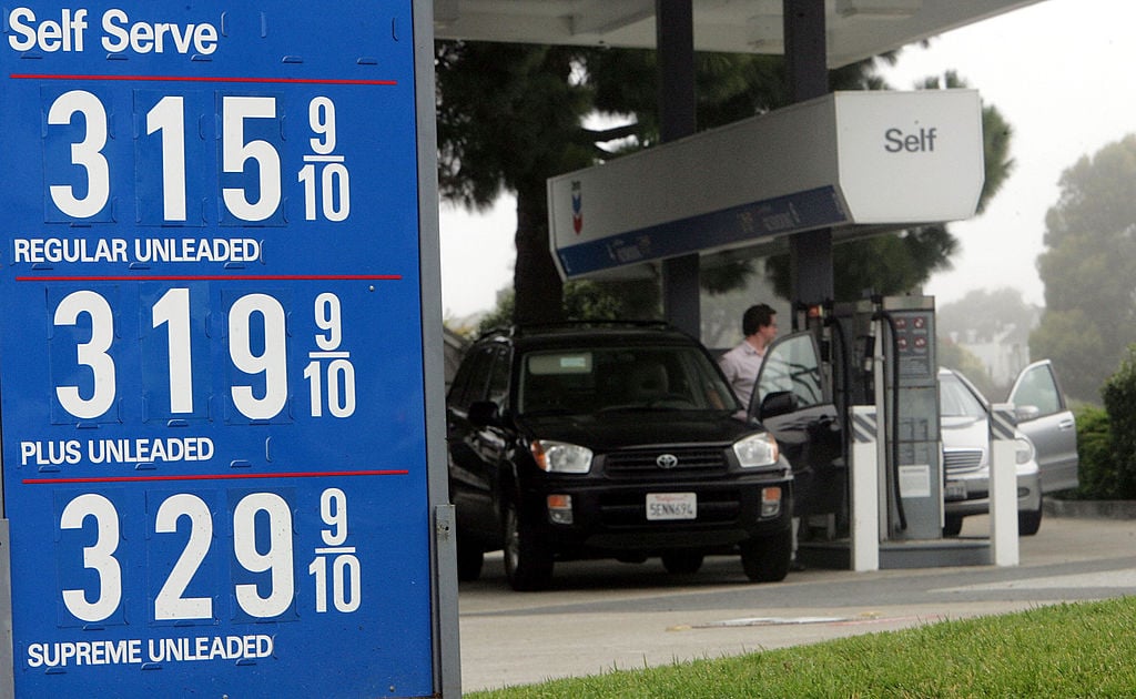 People fill their cars at a Chevron service station