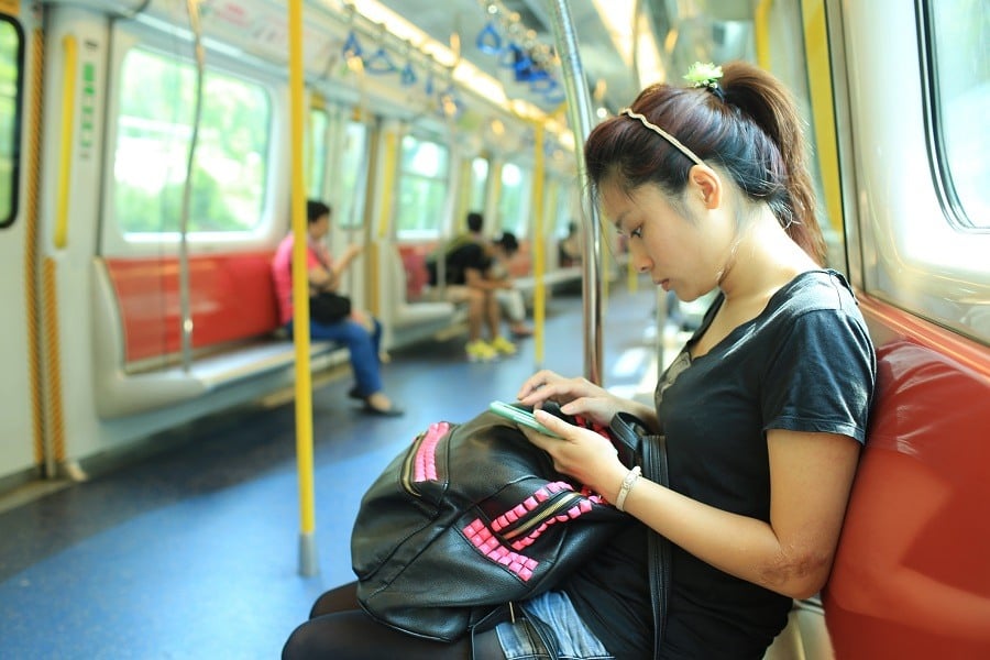 Girl playing on her smartphone on the subway