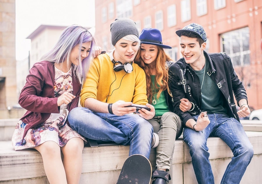 young teens playing videogames outdoors