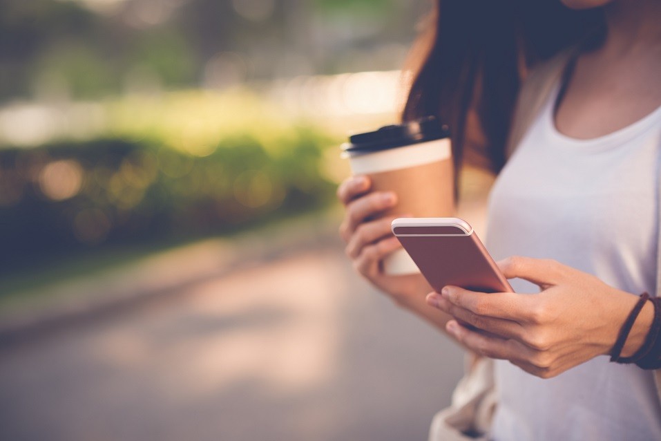 woman texting and drinking coffee