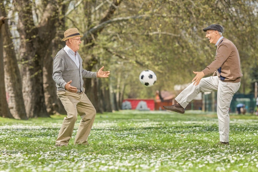 seniors playing soccer in a park seniors playing soccer in a park