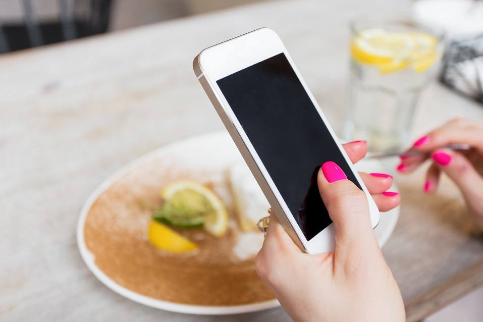 Woman holding mobile phone with empty black screen