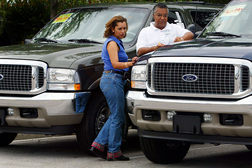 A woman looks at a new pick up truck for sale.