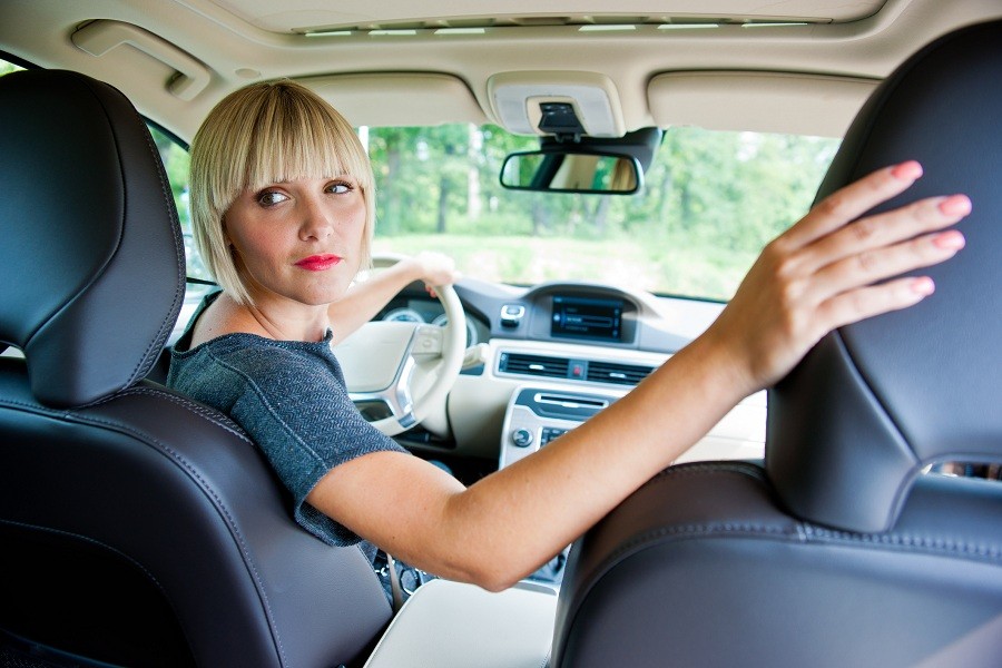 woman driver looking back and parking car