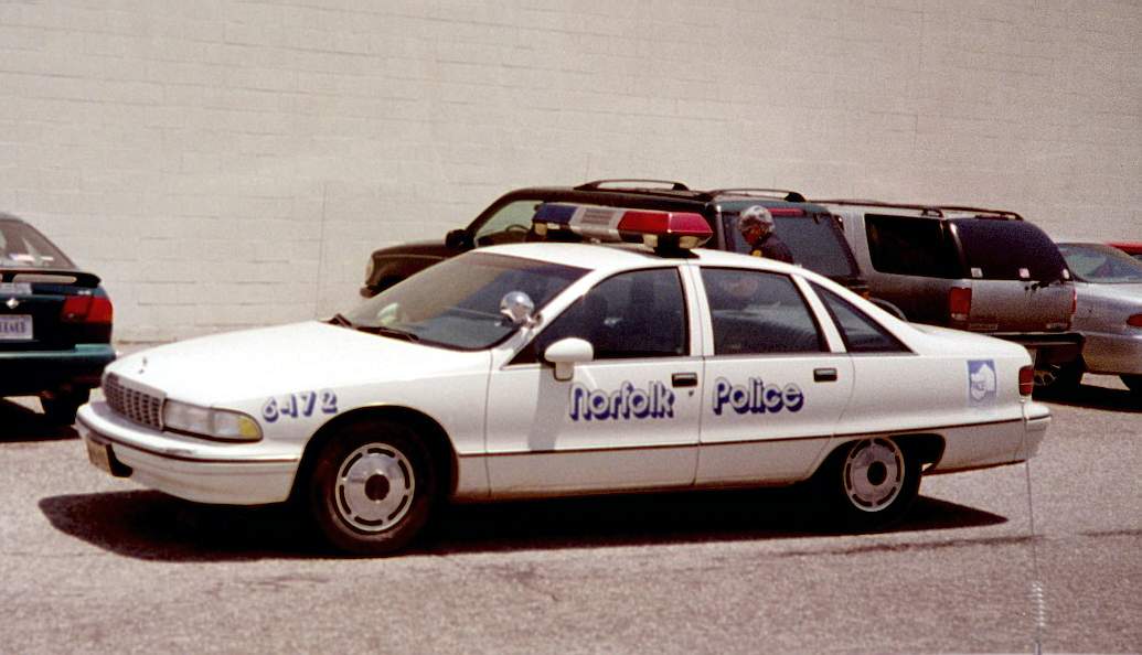 White Chevrolet Caprice American cop car in a parking lot.