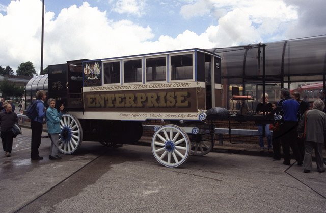 A group of people look at one of the oldest cars in the world, the Hancock Omnibus.