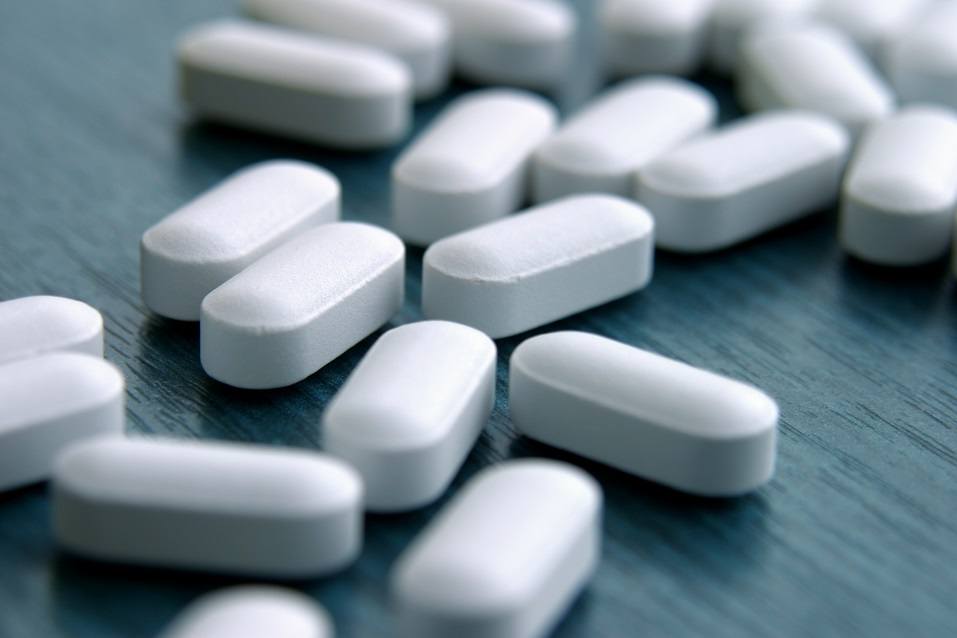 White pills spread out on a table, blurry front and back. White pills spread out on a table,blurry front and back.