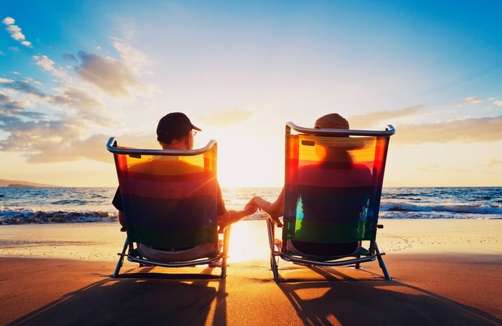senior couple of old man and woman sitting on the beach