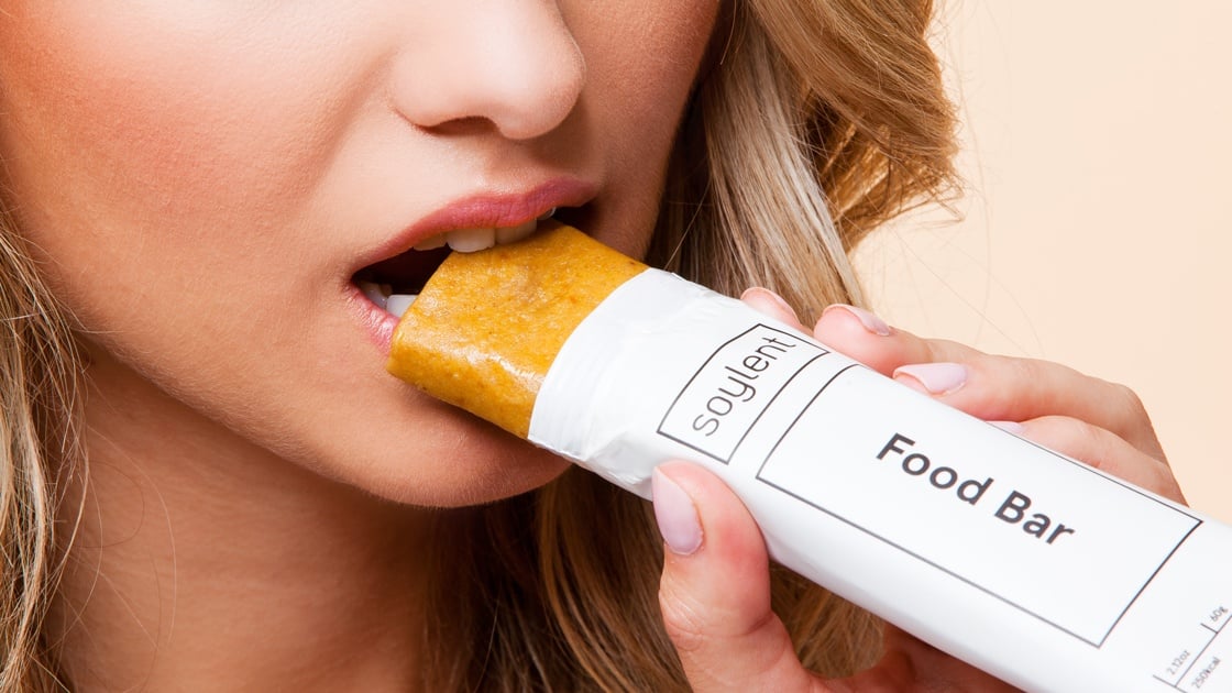 A woman eating a Soylent Food Bar