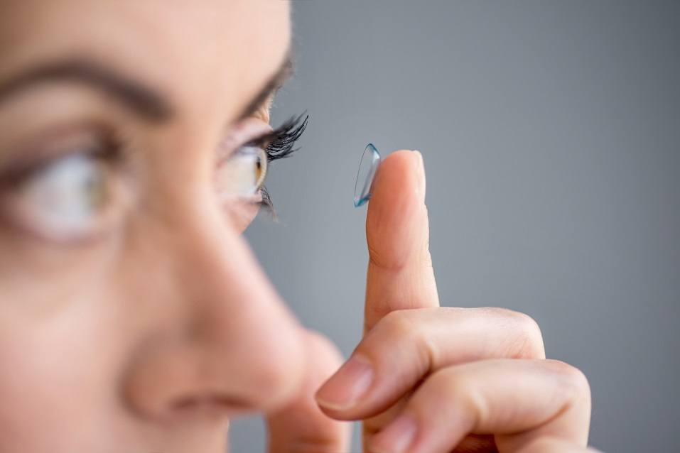 Attractive mature lady putting on contact lenses