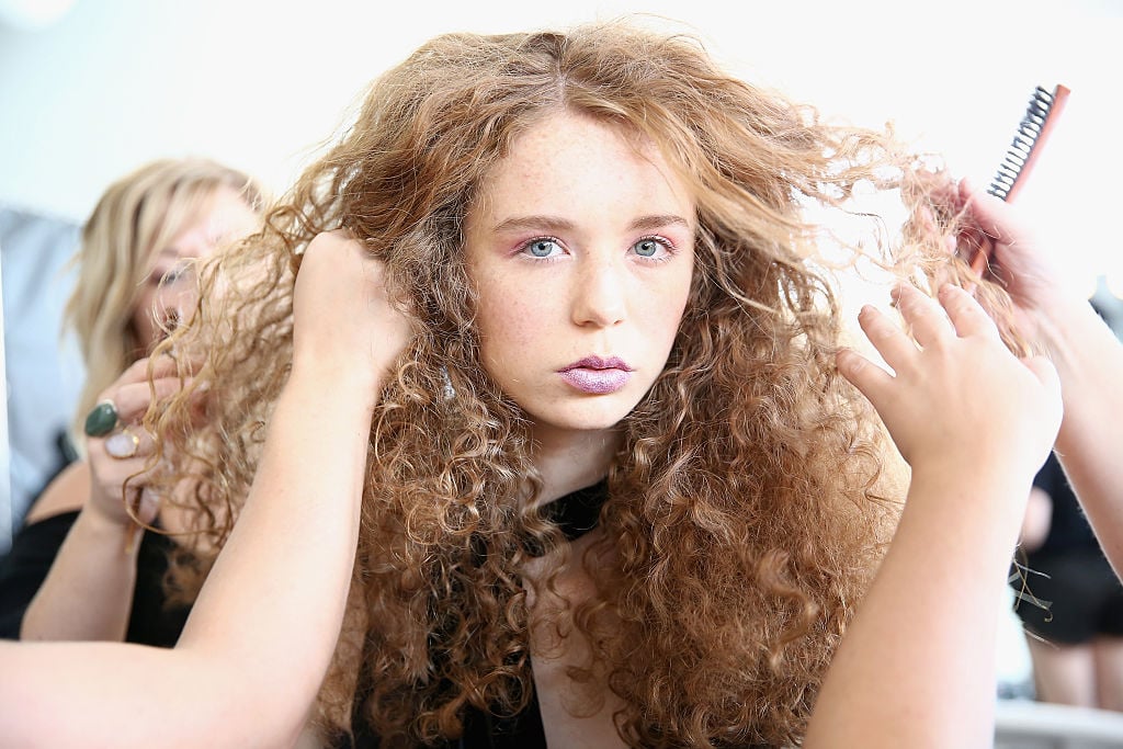 A model prepares her hair backstage at Concept Korea fashion show during New York Fashion Week